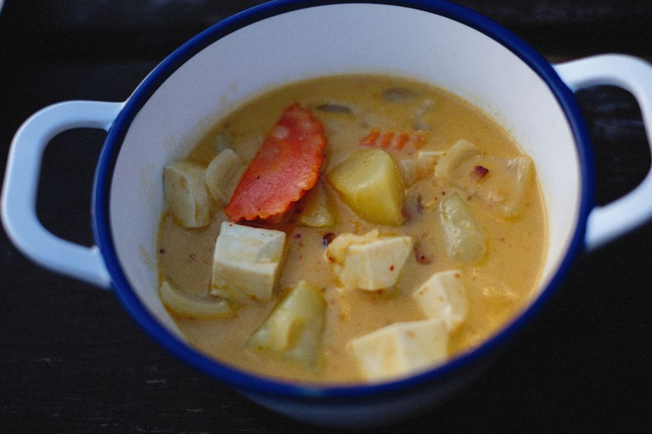 Delicious homemade tofu and vegetable soup served in a rustic white pot.