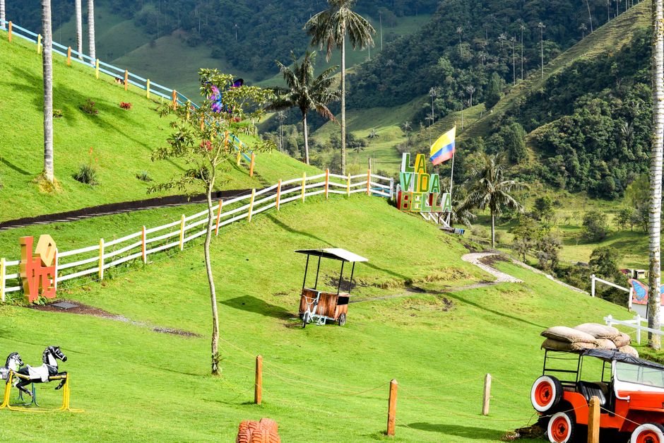 Vibrant Cocora Valley landscape with Colombian flag and rolling hills, perfect for tourism.