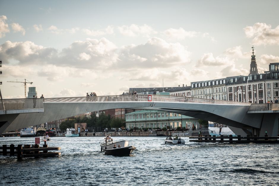 Scenic view of a modern drawbridge and boats in Copenhagen's bustling harbor.