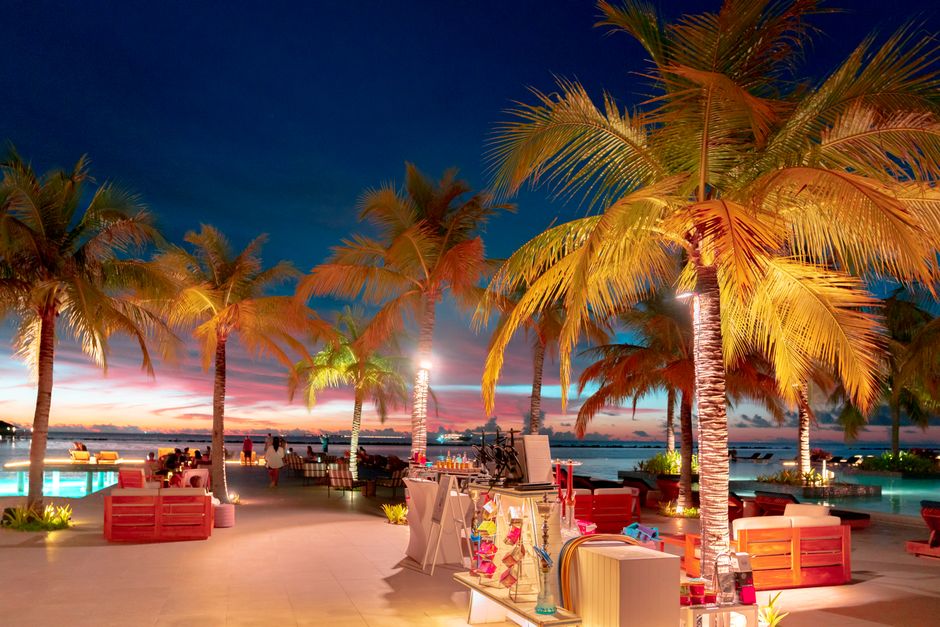 A luxurious tropical resort at dusk with palm trees and ocean views, perfect for a dreamy vacation.