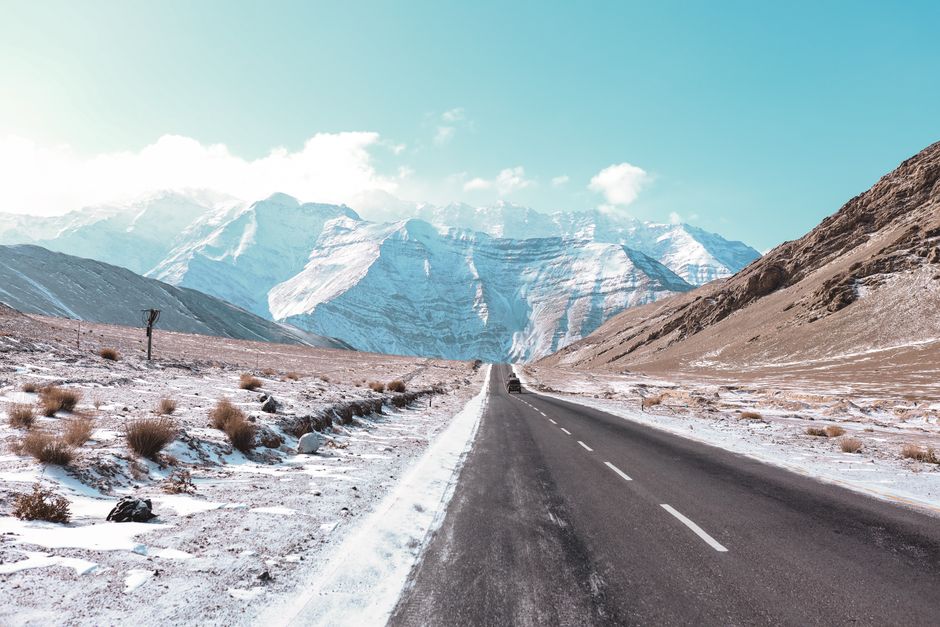 Beautiful highway view with snow-covered mountains in winter, perfect for travel and adventure enthusiasts.