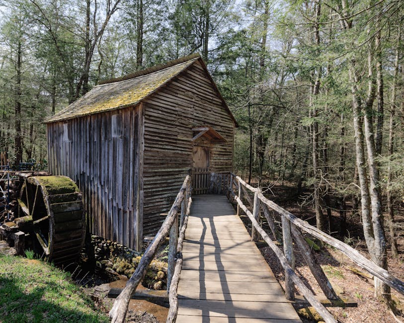 Rustic wooden grist mill with water wheel in a serene Tennessee forest, ideal for nature and history themes.